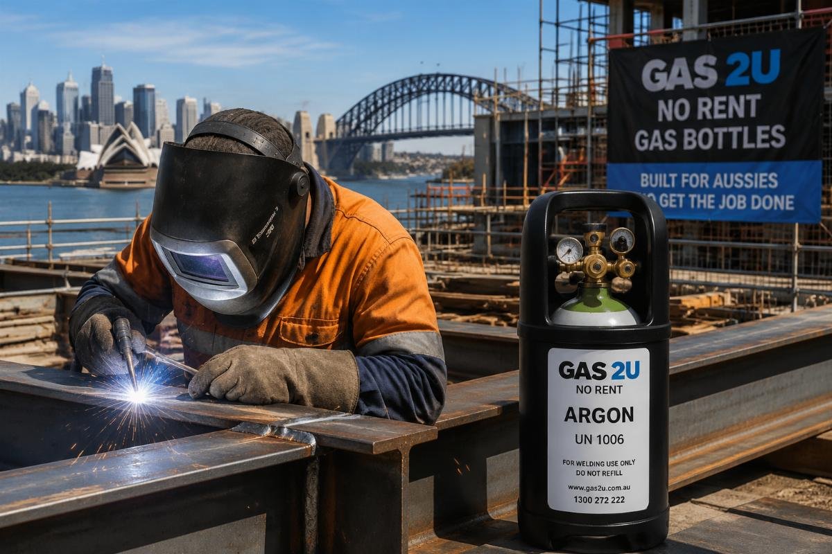 A construction welder working on a site with a portable no-rent argon bottle in the background